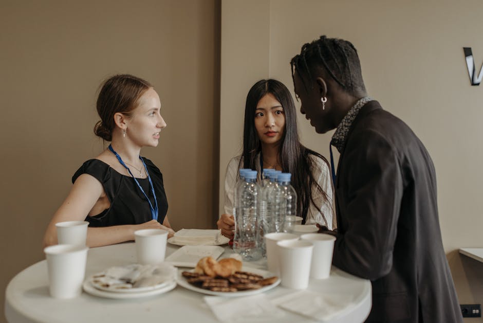 Three People Talking Near a Table